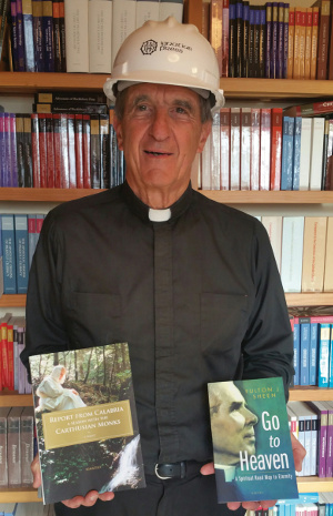 Image for: Fr. Joseph Fessio wearing an Ignatius Press hard hat and holding some of this season’s books.