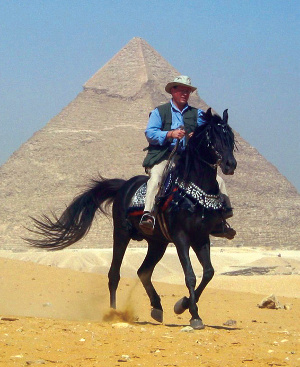 Footprints of God host Steve Ray riding a horse in front of an Egyptian pyramid.